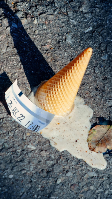 Gelato caduto per terra, vicino a biglietto parcheggio